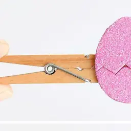 Pinza de madera sujeta un huevo de Pascua rosa brillante, perfecto para manualidades de Pascua.